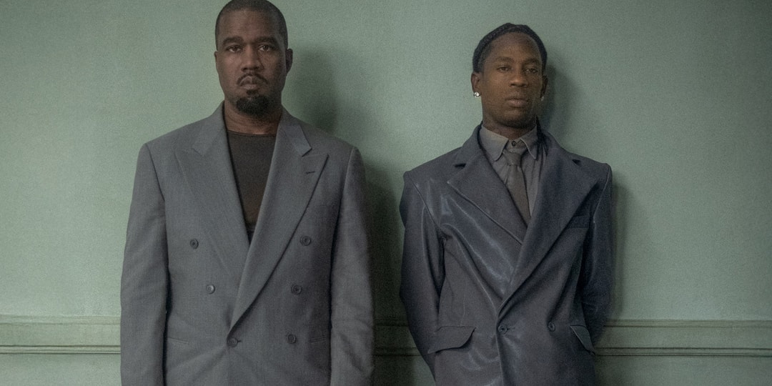 Deux hommes en costumes gris devant un fond vert.