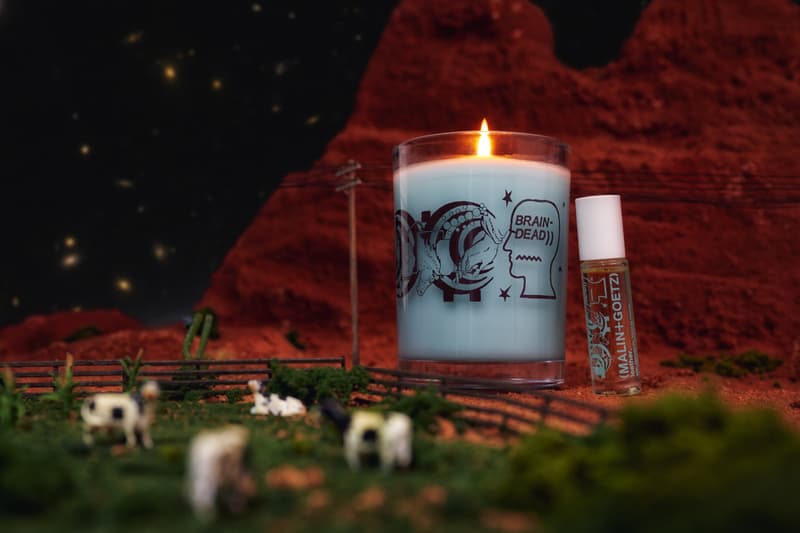 Bougie allumée avec décor miniature de ferme et ciel étoilé.