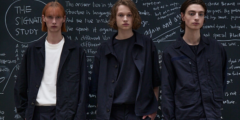 Trois mannequins posant devant un tableau noir avec des écritures blanches.