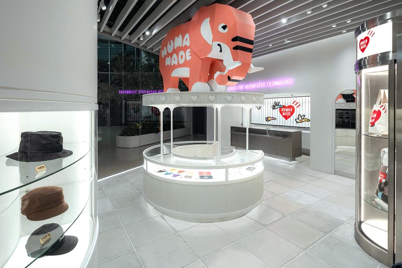 Magasin avec grand éléphant rose, chapeaux exposés, design moderne et lumineux.