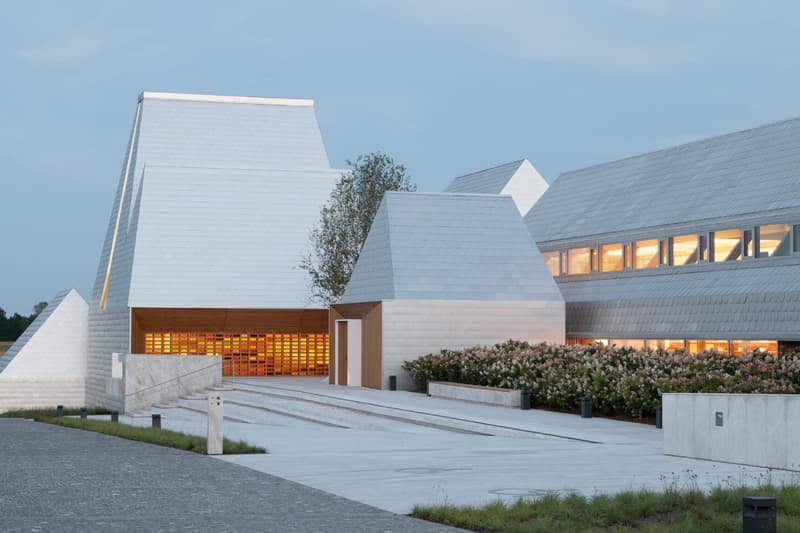 Bâtiment moderne avec toit en pente et éclairage intérieur visible